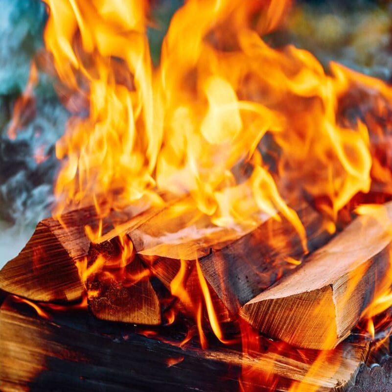 Burning Wood in Fire Pit Fire burning in a fire pit. Warm and cozy outdoor setting.